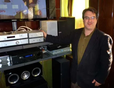 Dave Lalin beside a rack of audio electronics in the showroom